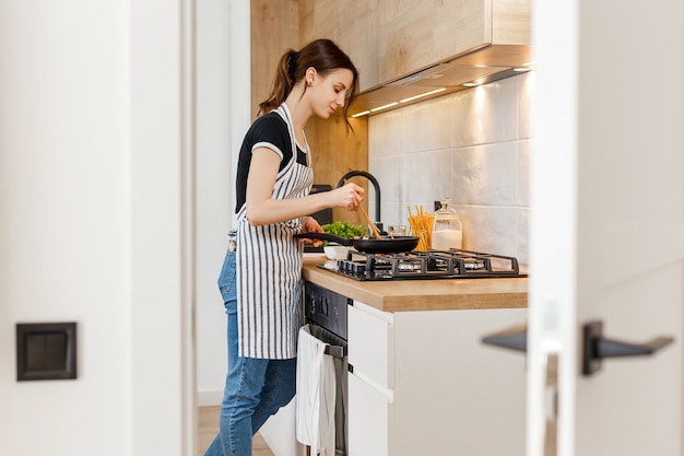 Donna che cucina cibo sano a casa cucina Concetto di stile di vita domestico casalinga tempo libero