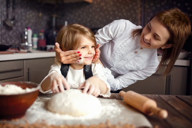 Donna che cucina e si diverte con la bambina