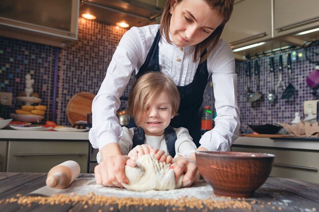 Donna che cucina e si diverte con la bambina