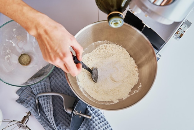 Donna che cucina in cucina e usa il robot da cucina