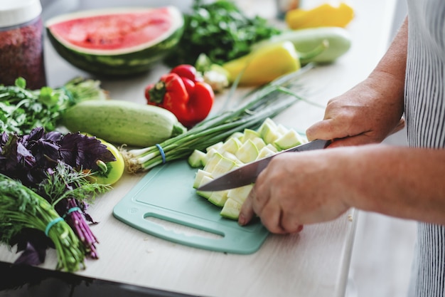 Donna che cucina le verdure in cucina.