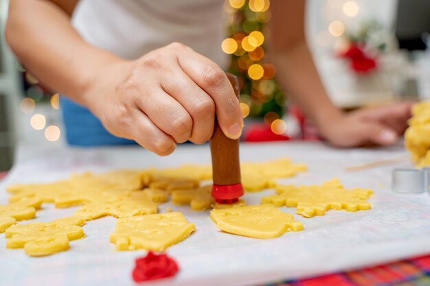 Donna che cucina pan di zenzero in vacanza invernale a casa. Biscotto di Natale fatto in casa per Natale e felice anno nuovo.