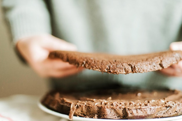Donna che cucina una torta al cioccolato in cucina a casa