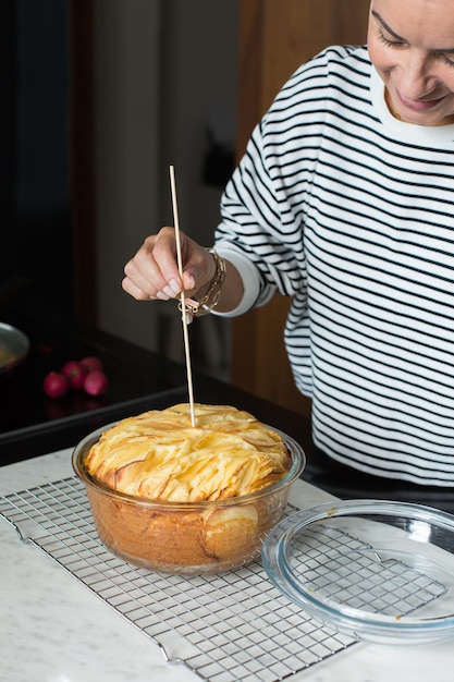 Donna che cuoce la torta di mele fatta in casa in cucina