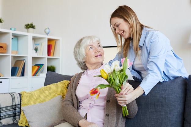 Donna che dà i fiori alla madre