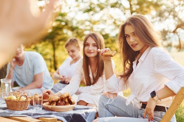 Donna che dà il cinque al fotografo Un gruppo di giovani ha una vacanza all'aperto nella foresta Concezione del fine settimana e dell'amicizia