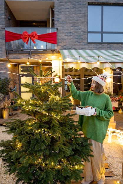 Donna che decora l'albero di Natale in cortile