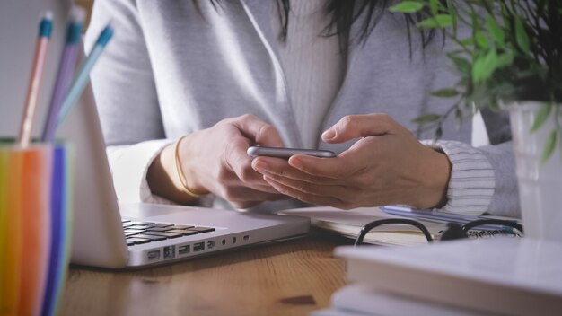 Donna che digita su uno smartphone mentre parla su un pho