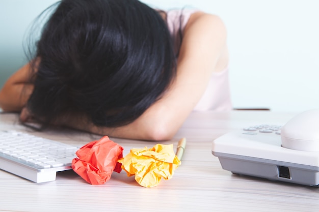 Donna che dorme con la testa sul tavolo davanti al computer