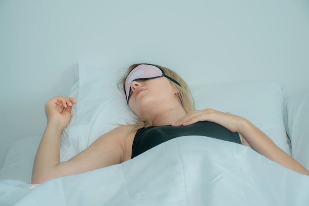 donna che dorme sul letto con maschera per dormire