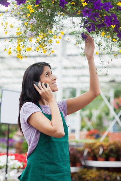 Donna che esamina i fiori nel canestro d&#39;attaccatura