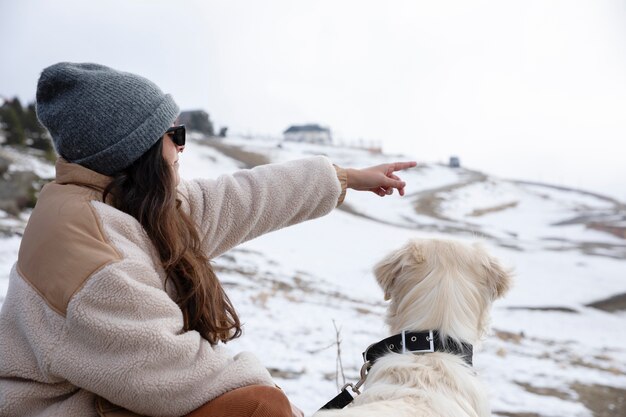 Donna che esplora con il suo labrador durante il viaggio invernale