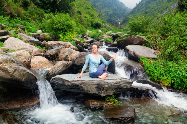 Donna che fa asana matsyendrasana di Ardha all'aperto