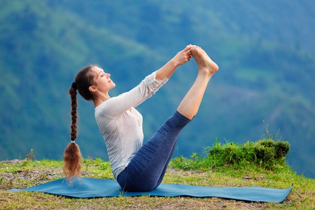 Donna che fa Ashtanga Vinyasa Yoga asana all'aperto