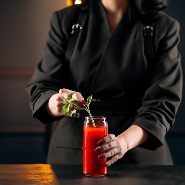 Donna che fa bloody mary cocktail con sedano