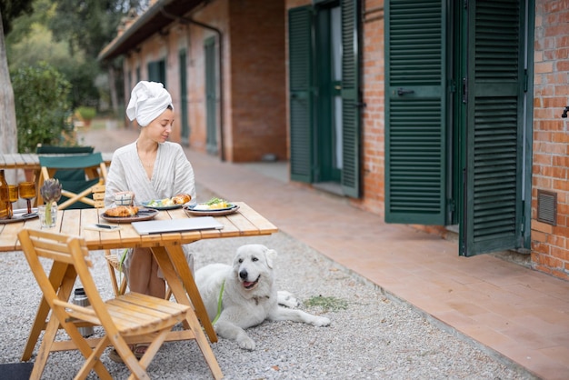 Donna che fa colazione sulla terrazza dell'hotel sulla natura