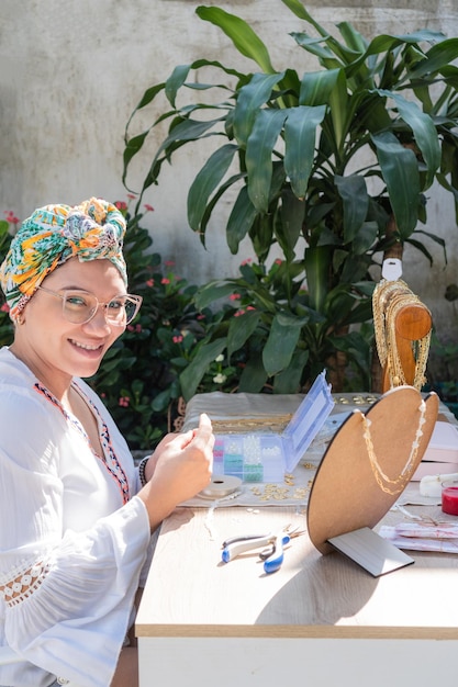 Donna che fa collane nel suo laboratorio di casa