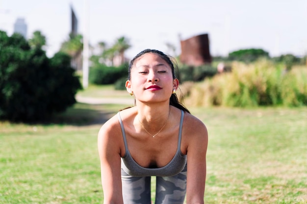 Donna che fa esercizi di yoga in parco