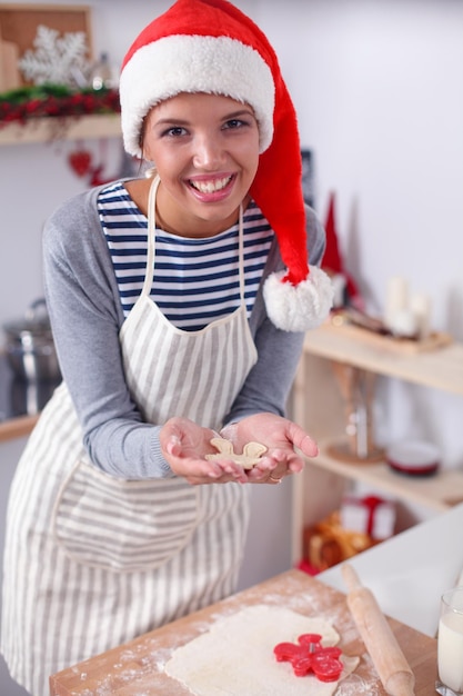 Donna che fa i biscotti di natale in cucina