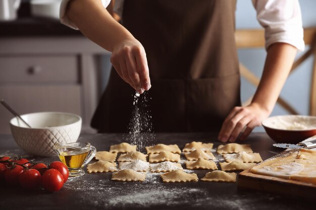 Donna che fa i ravioli sul tavolo