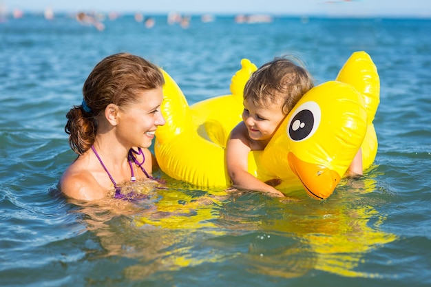 Donna che fa il bagno in mare con un bambino