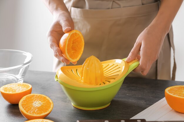 Donna che fa il succo di agrumi in cucina