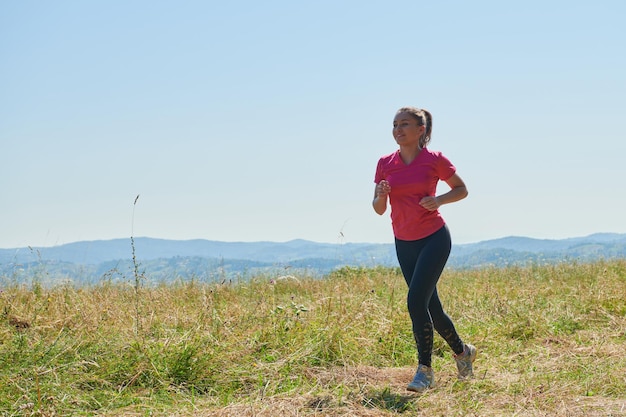 donna che fa jogging in uno stile di vita sano su una fresca aria di montagna nella bella natura estiva soleggiata