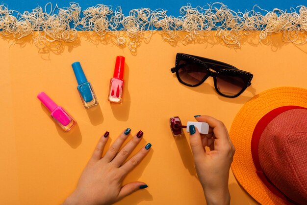 Donna che fa la manicure con diversi colori estivi di smalti per unghie