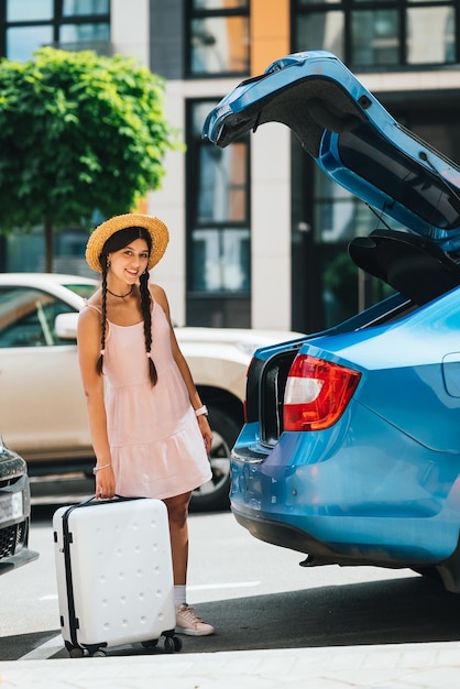 Donna che fa la valigia nel bagagliaio dell'auto