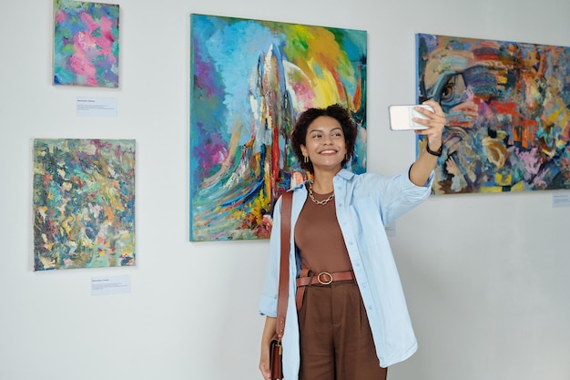 Donna che fa ritratto selfie in galleria d'arte