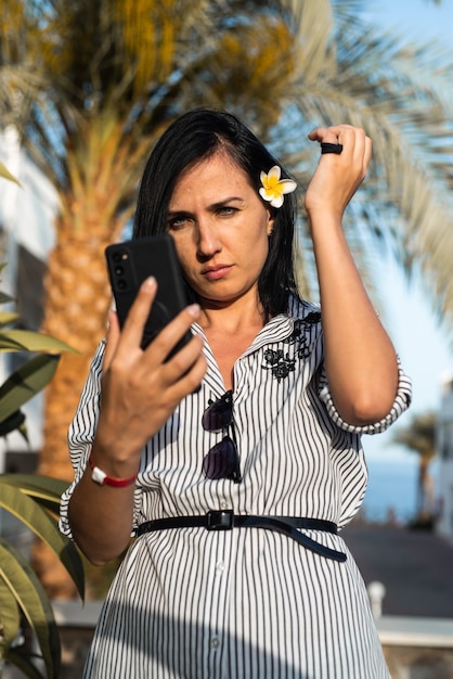 Donna che fa selfie vicino alla palma palm