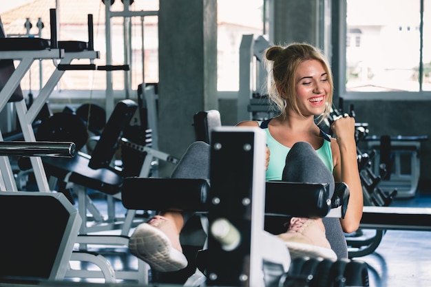 Donna che fa sit up e allenamento con i pesi in palestra sportiva con concetto di allenamento in palestra felice e sorridente