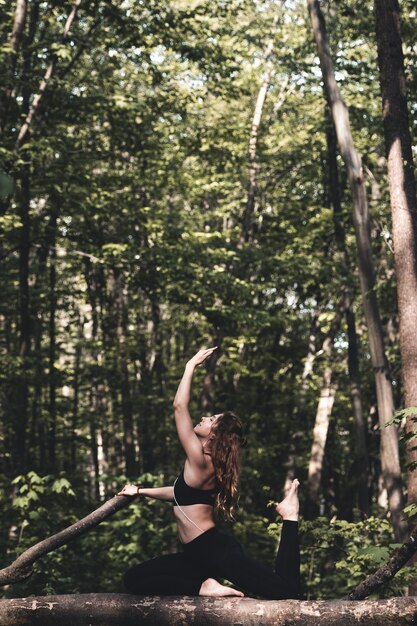 Donna che fa sport e ascolta la musica nella foresta e fa esercizi Jogging