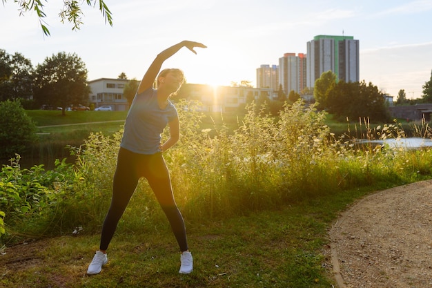 Donna che fa sport in campagna al tramonto