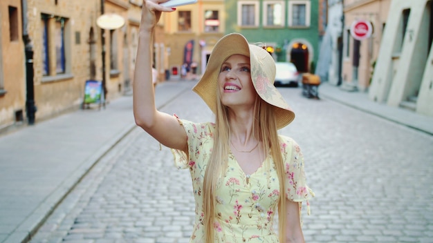 Donna che fa un giro turistico e che fa i colpi. Ragazza allegra che fa un giro turistico e che prende i colpi sulla vecchia via della città.