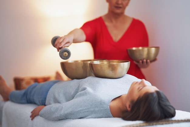 Donna che fa un massaggio tibetano con campane sonore