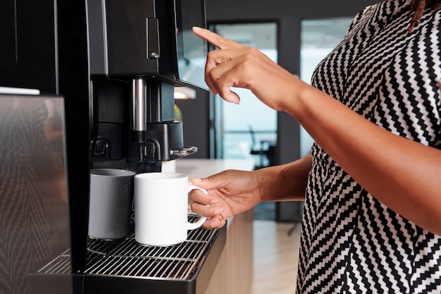 Donna che fa una tazza di caffè