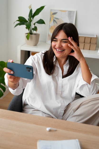 Donna che fa una videochiamata a casa con uno smartphone