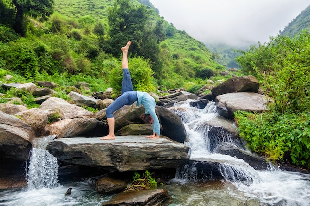 Donna che fa yoga asana alla cascata