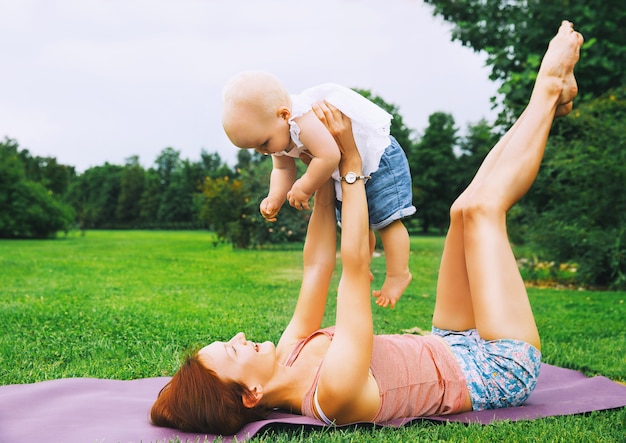 donna che fa yoga con il bambino nel parco estivo Famiglia all'aperto Genitore con figlio trascorre del tempo insieme