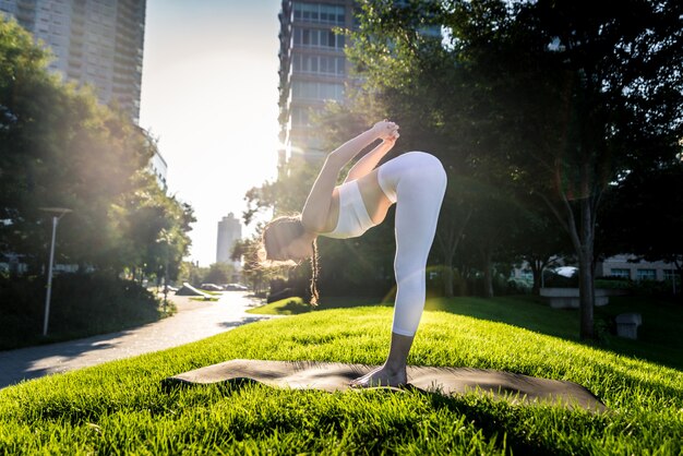 Donna che fa yoga in un parco