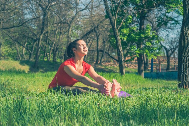 Donna che fa yoga sull'erba verde