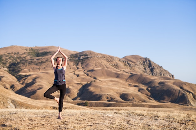 donna che fa yoga sulla natura all'aperto