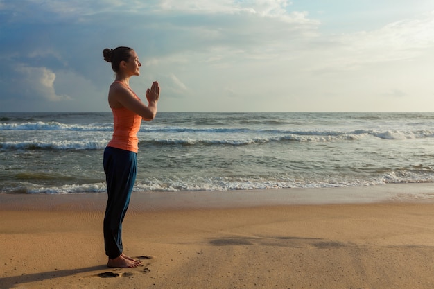 Donna che fa yoga sulla spiaggia