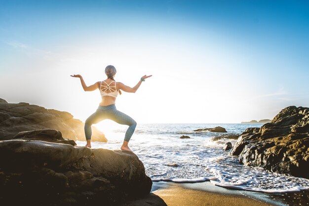 Donna che fa yoga sulla spiaggia