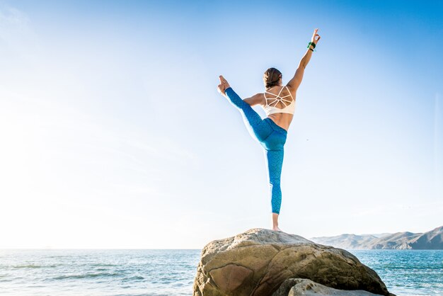 Donna che fa yoga sulla spiaggia