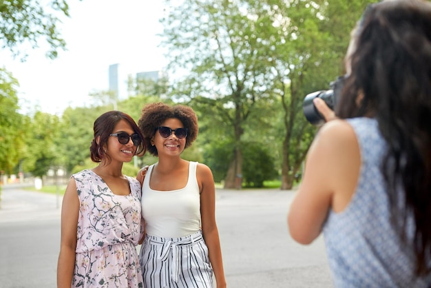 donna che fotografa i suoi amici nel parco estivo