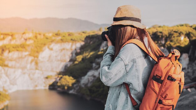 Donna che fotografa in piedi contro la montagna