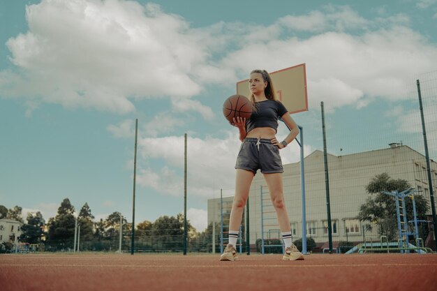 Donna che gioca a basket sul campo sportivo