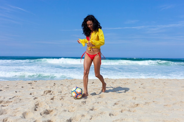 Donna che gioca a palla sulla spiaggia, Rio de Janeiro.